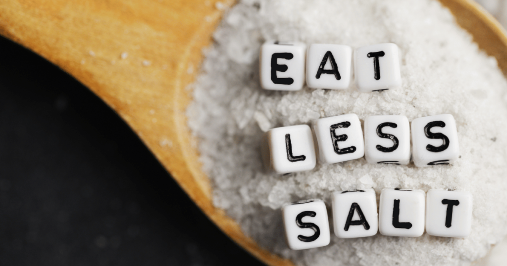 EAT LESS SALTと書かれたサイコロが塩の上に載っている写真。